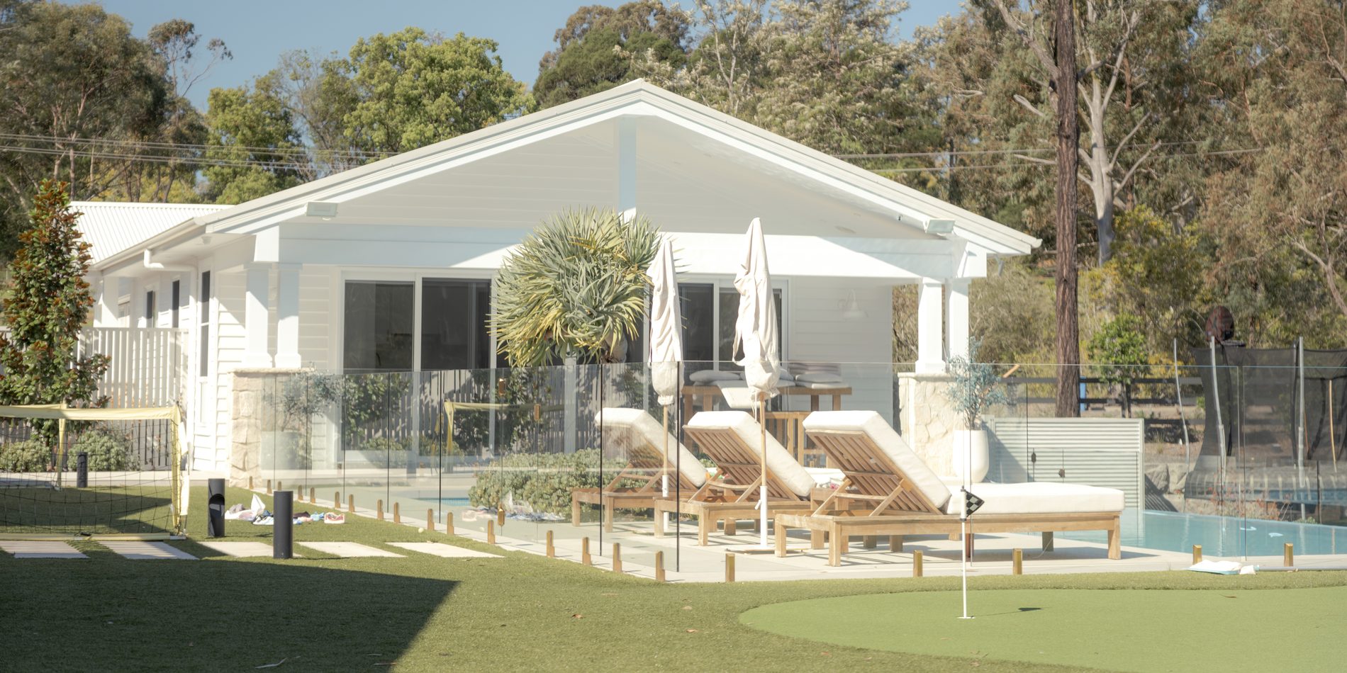 The rear elevation across the lawn, cabana and pool beyond