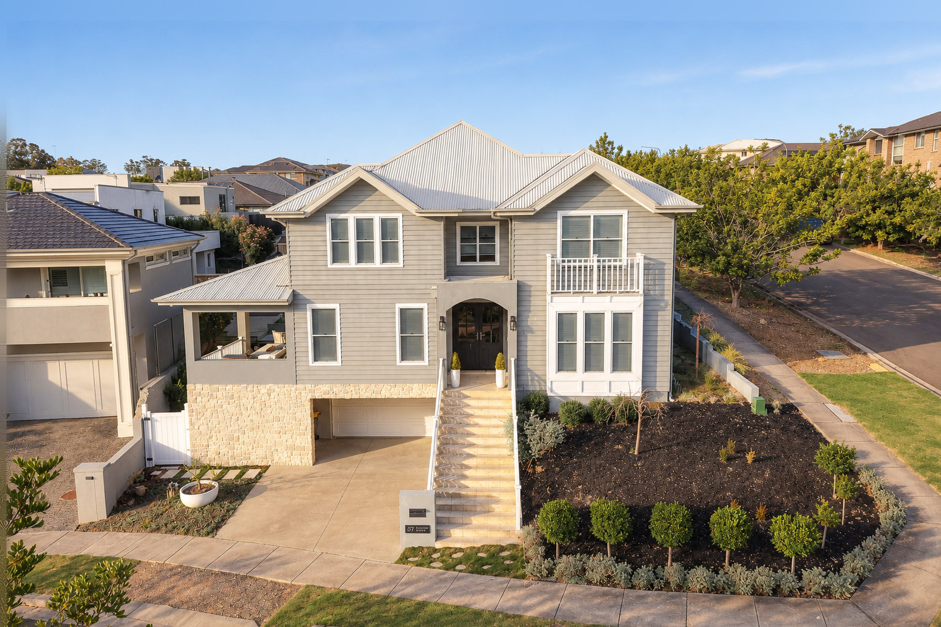 Two-storey weatherboard home on a sloping corner block