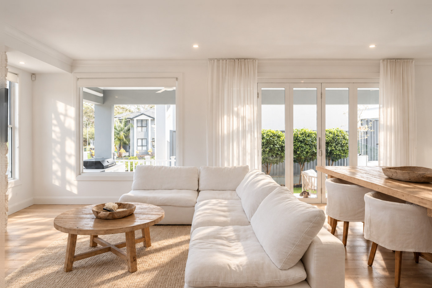 Living room, with sheer curtains over the bi-fold doors
