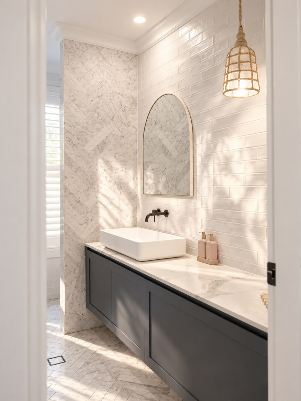 Bathroom vanity against marble herringbone and gloss subway tile