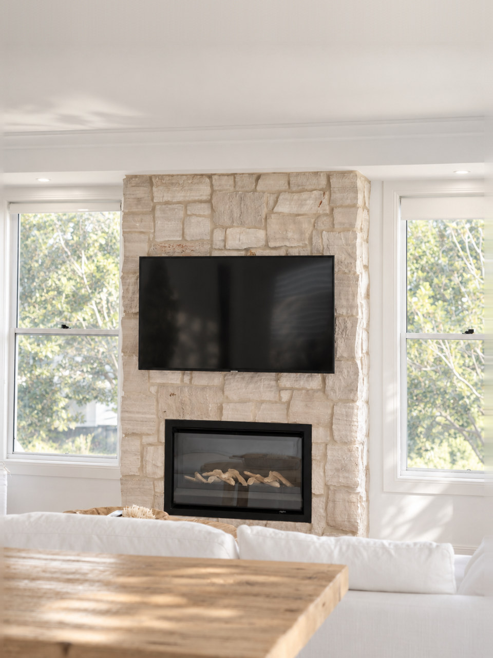 The stone fireplace between the double-hung windows