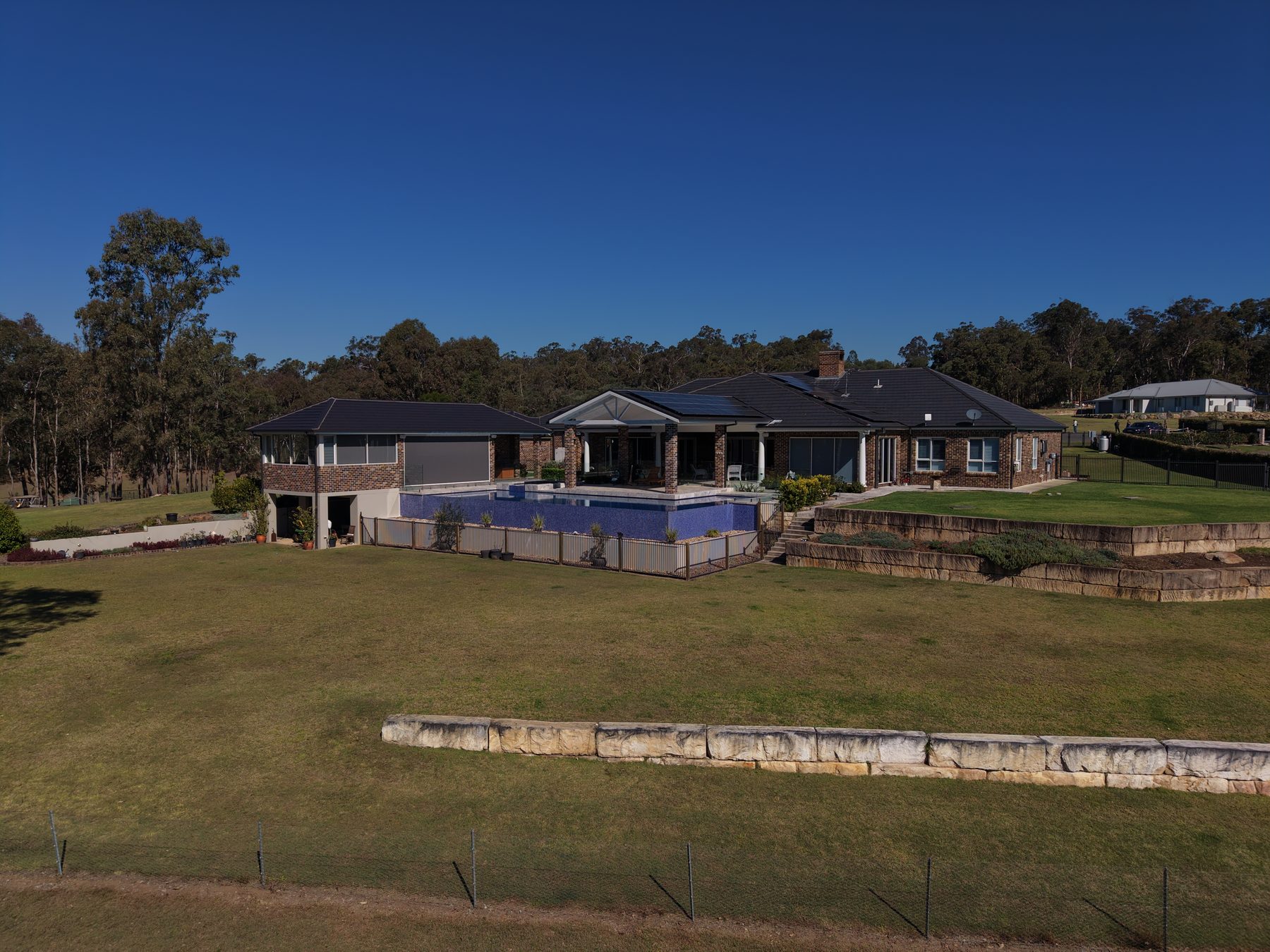 Elevated pool and sandstone terracing at an acreage home